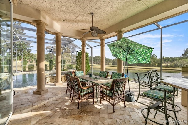 sunroom featuring decorative columns and ceiling fan