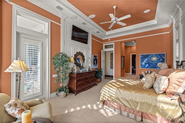 carpeted bedroom featuring crown molding and a tray ceiling