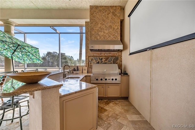 interior space with sink, a kitchen breakfast bar, cream cabinetry, light stone countertops, and wall chimney exhaust hood