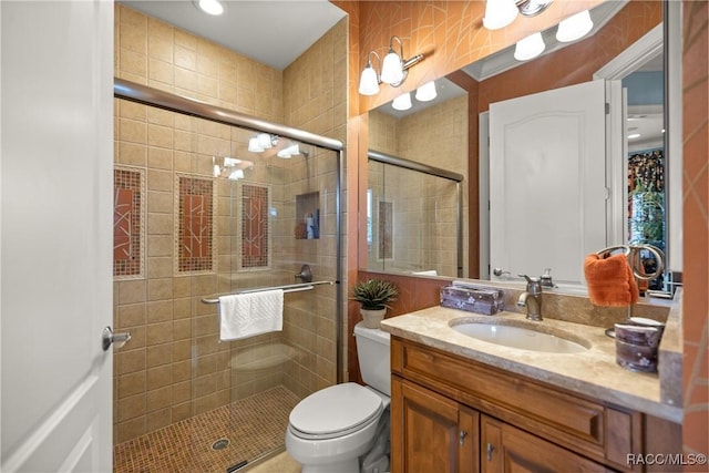 bathroom with walk in shower, vanity, and toilet