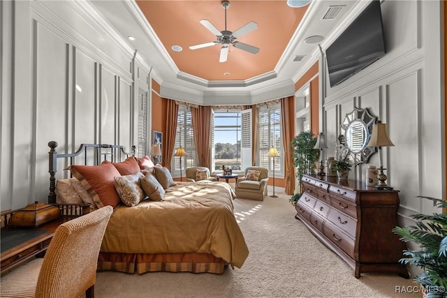 bedroom with a raised ceiling, ornamental molding, light colored carpet, and ceiling fan