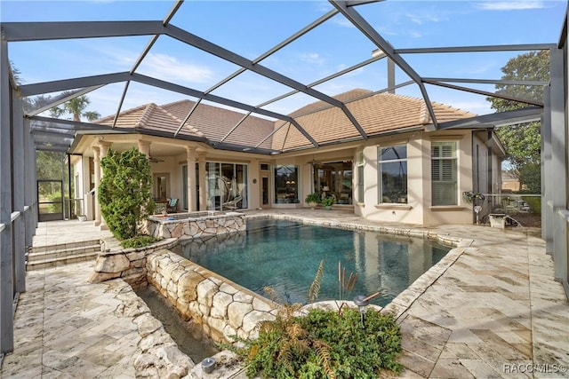 view of swimming pool featuring a patio, ceiling fan, and glass enclosure