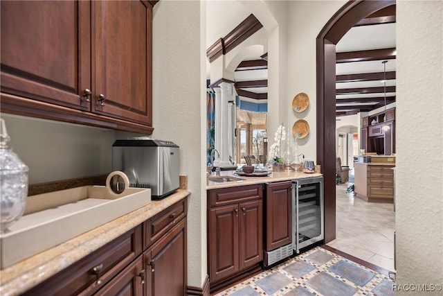 kitchen with wine cooler, beam ceiling, and sink