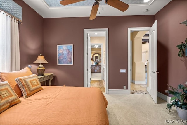 carpeted bedroom with ceiling fan and ensuite bath