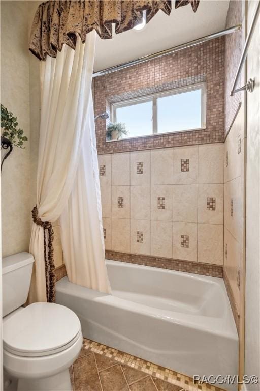 bathroom featuring shower / tub combo, tile patterned floors, and toilet