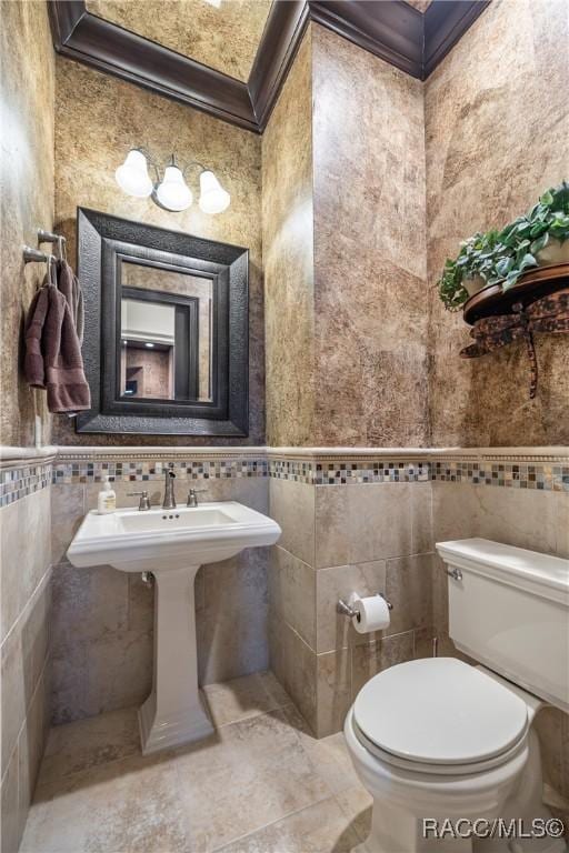 bathroom with tile walls and toilet