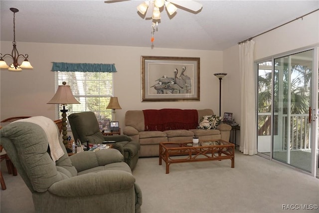 living room with ceiling fan with notable chandelier and light colored carpet