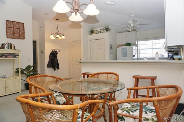 carpeted dining room featuring vaulted ceiling and ceiling fan with notable chandelier