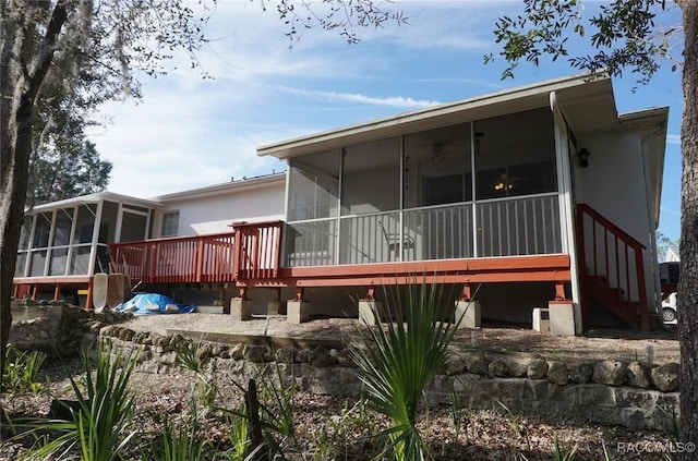 rear view of house featuring a sunroom, a deck, and ceiling fan