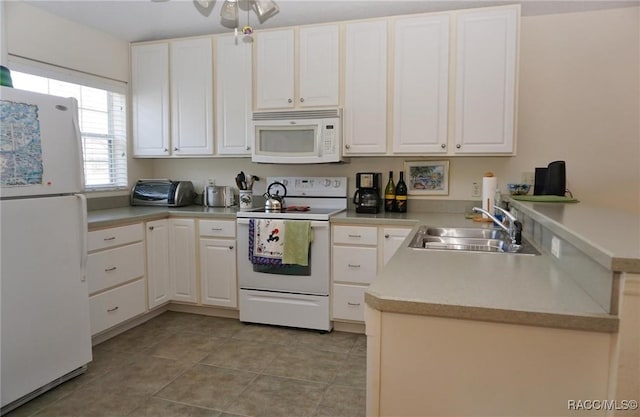 kitchen with sink, white appliances, light tile patterned floors, ceiling fan, and white cabinets