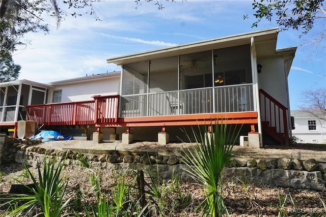 rear view of property with a wooden deck and a sunroom