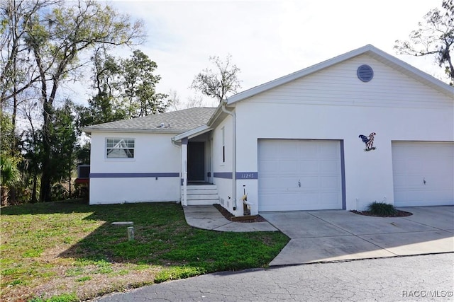 ranch-style home with a garage and a front lawn