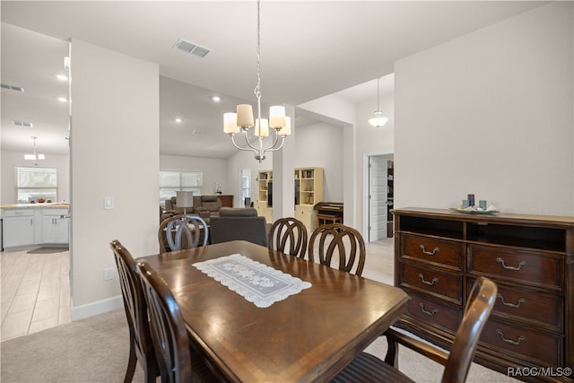 dining space featuring light carpet and a chandelier