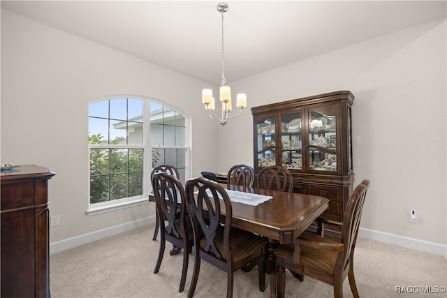 carpeted dining area featuring plenty of natural light and a chandelier