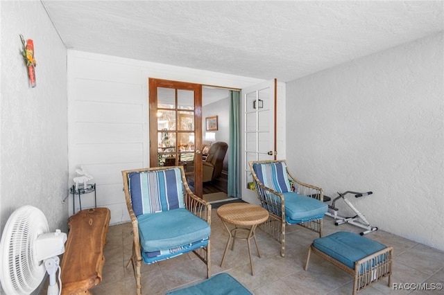 sitting room with tile patterned floors and a textured ceiling