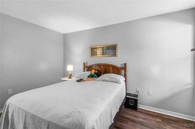 bedroom with dark wood-type flooring