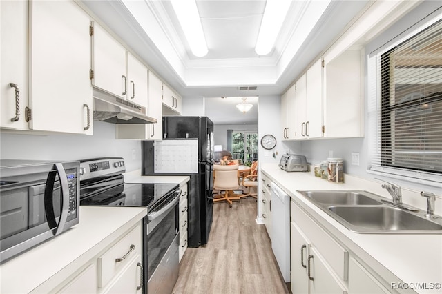 kitchen with a raised ceiling, sink, appliances with stainless steel finishes, light hardwood / wood-style floors, and white cabinetry