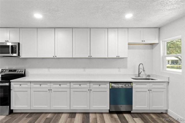 383 S Rooks Ave, Inverness, FL 34453 - kitchen featuring light countertops, stainless steel appliances, dark wood-type flooring, a sink, and white cabinets