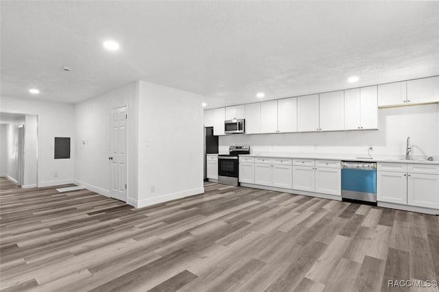 383 S Rooks Ave, Inverness, FL 34453 - kitchen with electric panel, a sink, light wood finished floors, appliances with stainless steel finishes, and recessed lighting