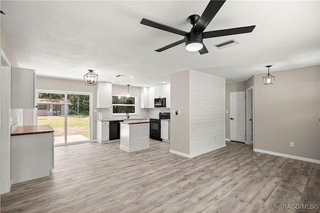 1361 NW 19th St, Crystal River, FL 34428 - kitchen featuring black appliances, open floor plan, light wood-type flooring, and white cabinetry