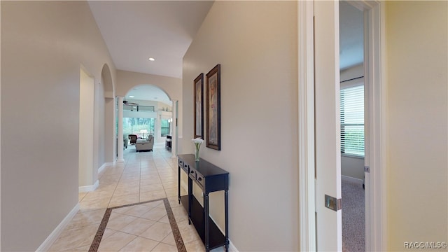 corridor with baseboards, arched walkways, and recessed lighting