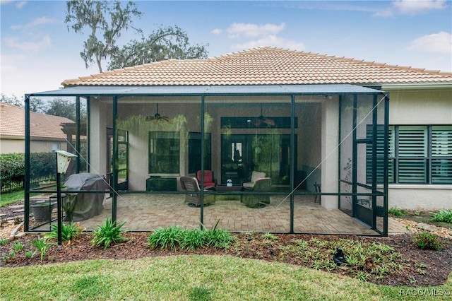 back of property featuring a patio area, a tile roof, and a ceiling fan