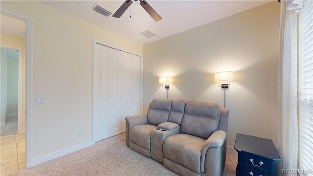 sitting room with a ceiling fan, visible vents, light carpet, and baseboards