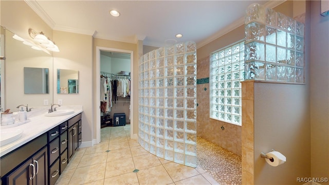 full bathroom featuring double vanity, walk in shower, crown molding, a healthy amount of sunlight, and a sink