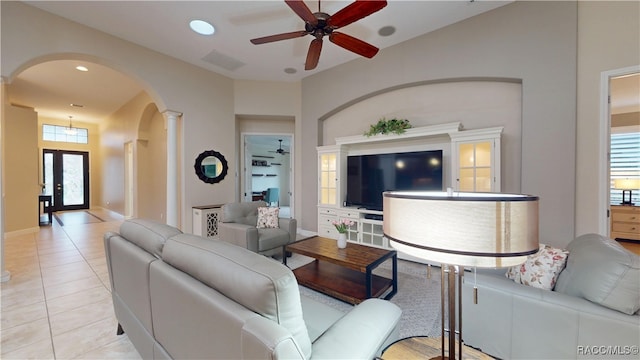 living room featuring arched walkways, decorative columns, light tile patterned floors, recessed lighting, and a ceiling fan