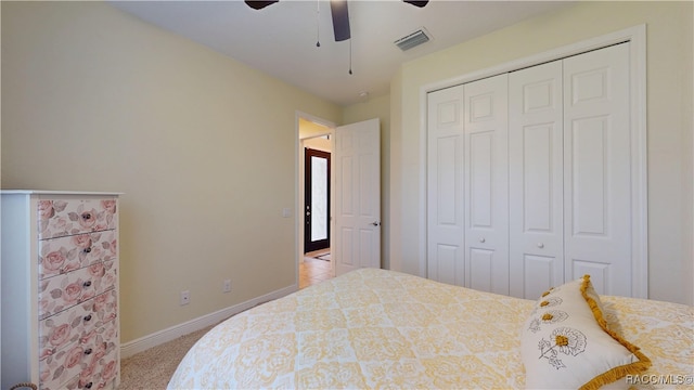 bedroom featuring light carpet, baseboards, visible vents, a ceiling fan, and a closet