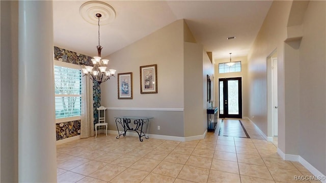 entrance foyer with a healthy amount of sunlight, baseboards, and light tile patterned flooring