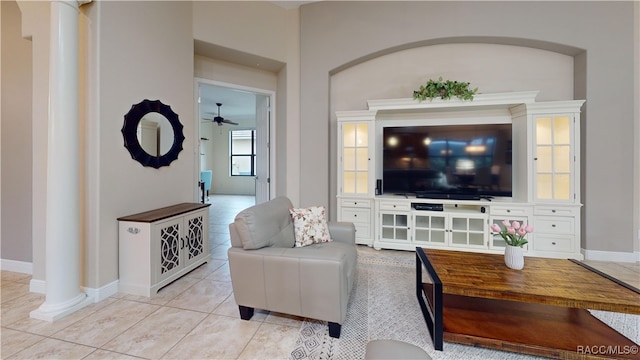 living room with light tile patterned floors, baseboards, and a ceiling fan