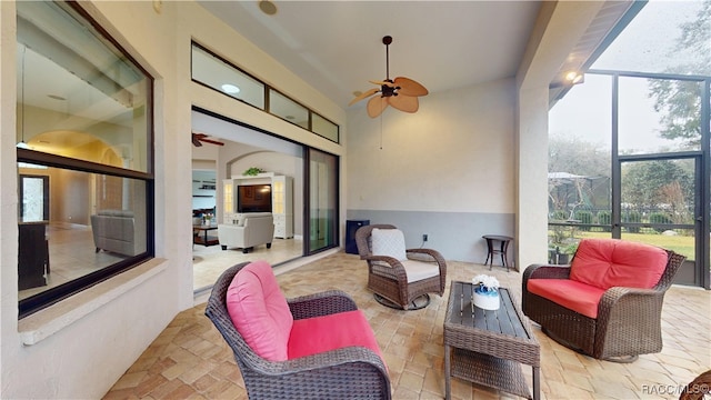 view of patio / terrace with glass enclosure, an outdoor living space, and a ceiling fan