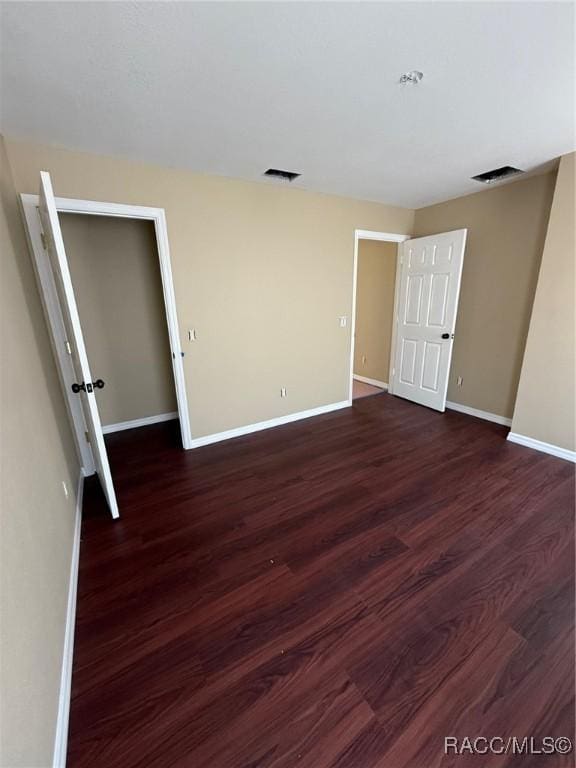 unfurnished bedroom featuring dark wood-type flooring