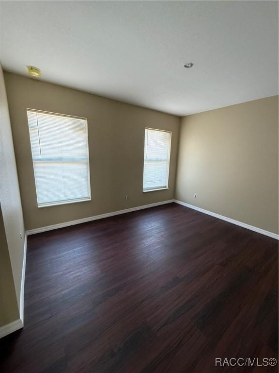 spare room with dark hardwood / wood-style flooring