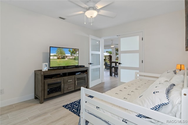 bedroom with ceiling fan, light hardwood / wood-style floors, and french doors