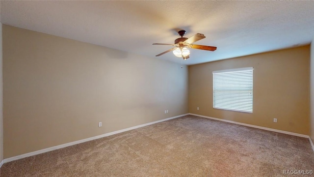 empty room featuring a textured ceiling, carpet flooring, baseboards, and ceiling fan