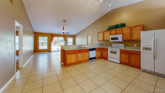 kitchen with light tile patterned flooring, white appliances, light countertops, and a peninsula