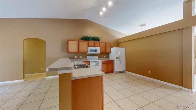 kitchen featuring visible vents, light countertops, arched walkways, white appliances, and a sink