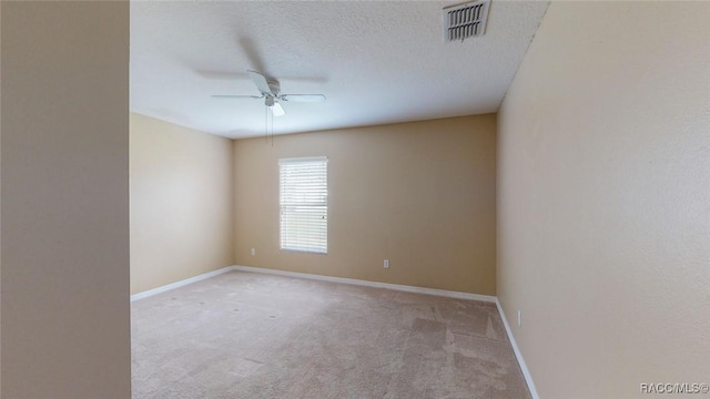 spare room with visible vents, baseboards, carpet, ceiling fan, and a textured ceiling