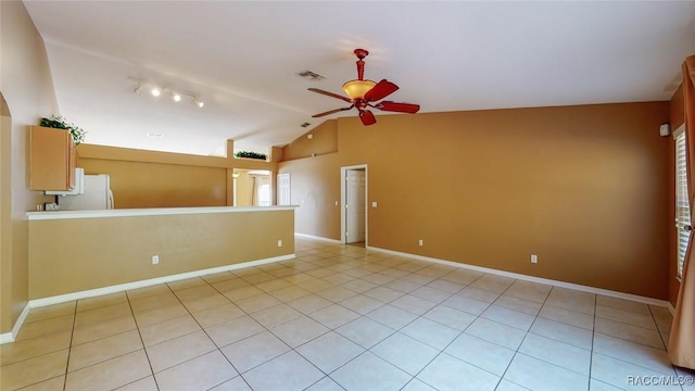 spare room with light tile patterned floors, a ceiling fan, visible vents, baseboards, and lofted ceiling