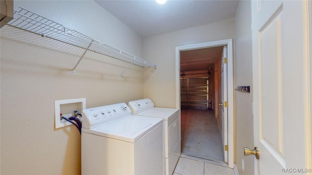 washroom featuring light tile patterned floors, laundry area, and separate washer and dryer