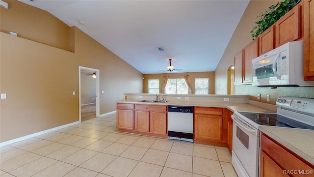 kitchen featuring a sink, white appliances, a peninsula, and light tile patterned floors