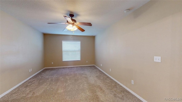 unfurnished room with carpet flooring, ceiling fan, a textured ceiling, and baseboards