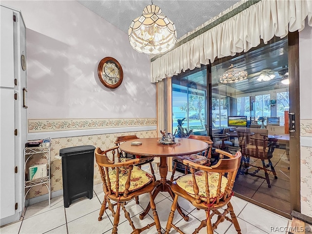 dining space featuring tile patterned flooring, a textured ceiling, and a wealth of natural light