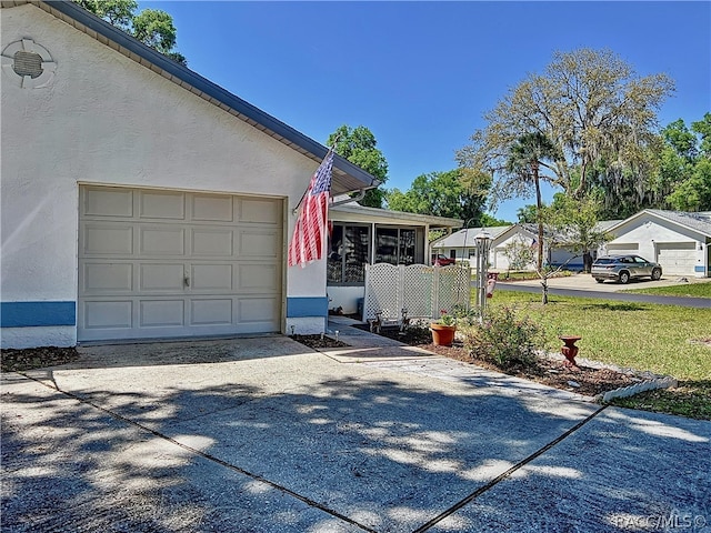 view of side of home featuring a garage and a sunroom