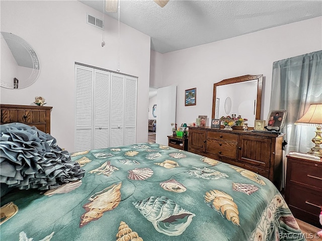 bedroom with ceiling fan, a closet, and a textured ceiling