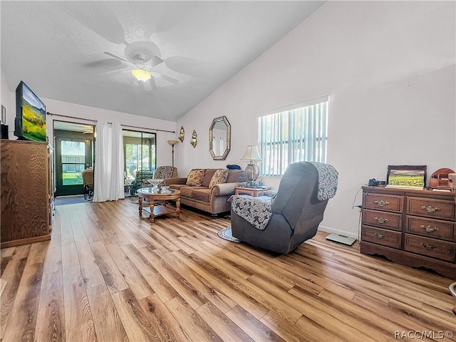 living room with lofted ceiling, ceiling fan, light wood-type flooring, and a wealth of natural light