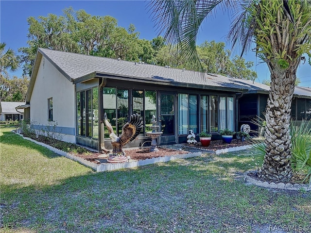 back of house with a yard and a sunroom