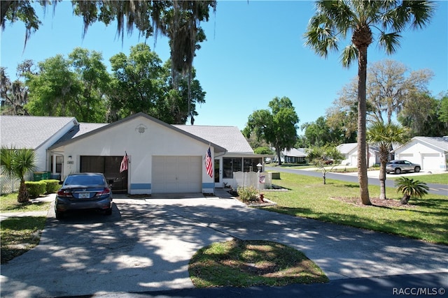 view of front of home with a sunroom, a garage, and a front yard